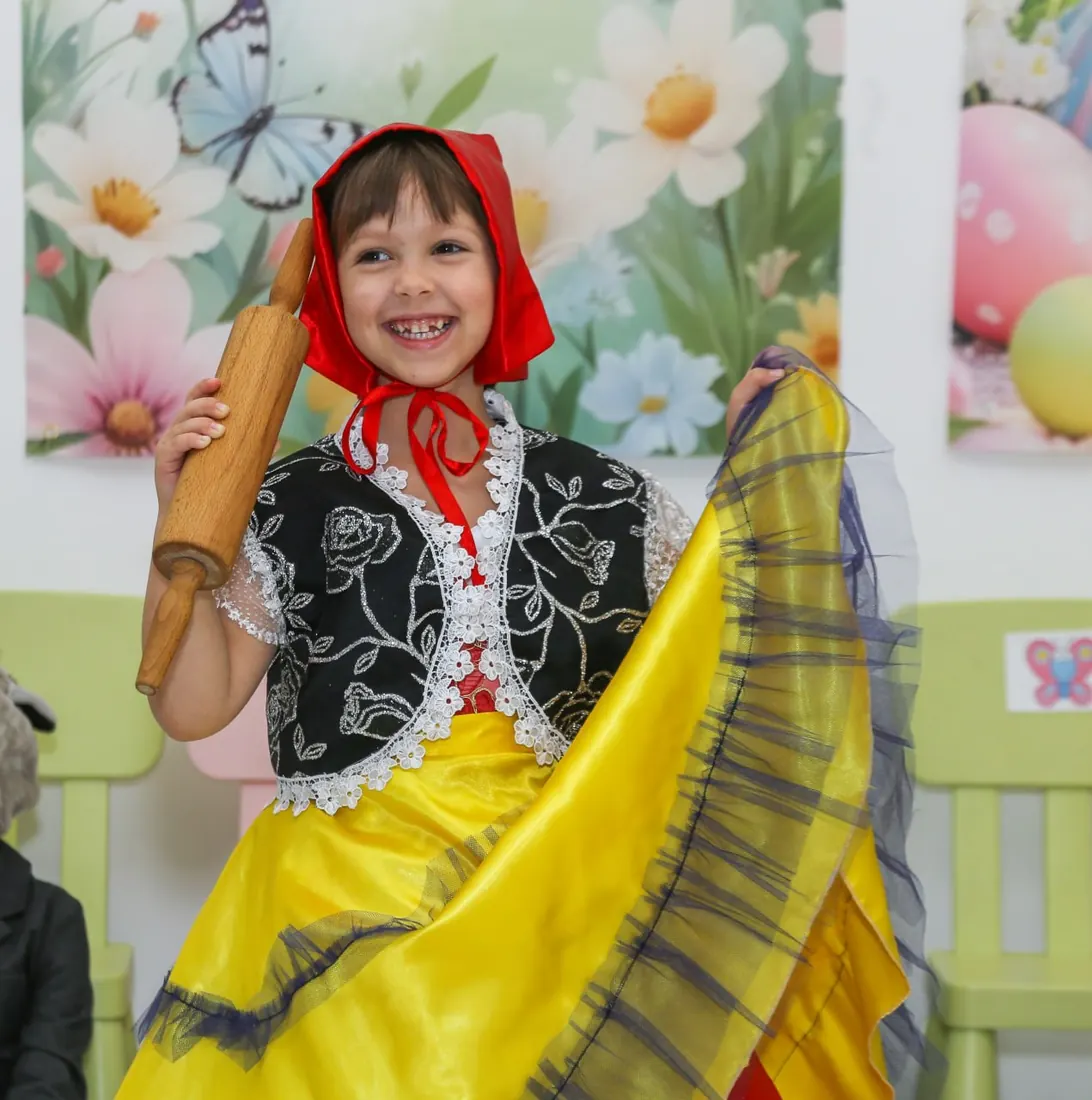 Дівчинка зі скалкою танцює у святковому костюмі